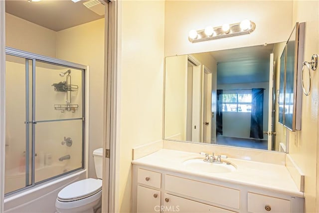 full bathroom with toilet, bath / shower combo with glass door, and vanity