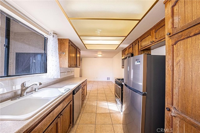 kitchen with light tile patterned floors, stainless steel appliances, and sink