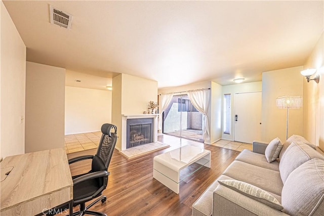 living room with hardwood / wood-style flooring and a tile fireplace