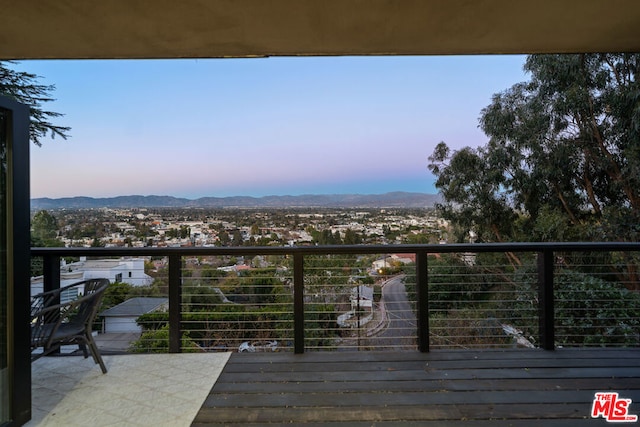 deck at dusk featuring a mountain view