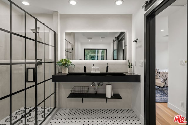 bathroom with walk in shower, sink, and hardwood / wood-style flooring