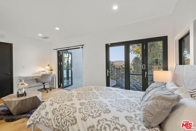 bedroom featuring access to outside, multiple windows, and light hardwood / wood-style floors