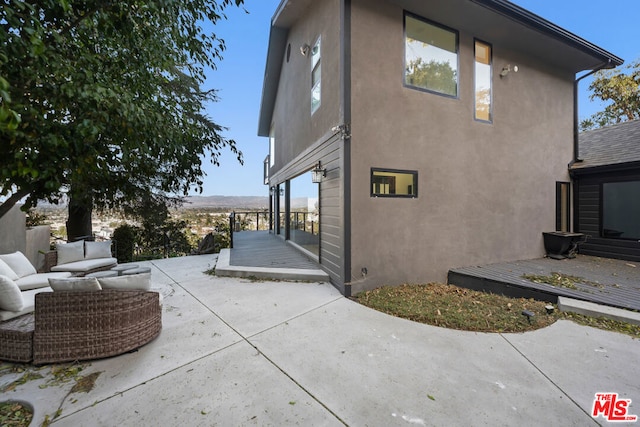 view of side of home featuring a patio area and outdoor lounge area