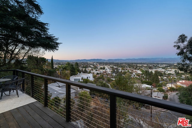 deck at dusk featuring a mountain view