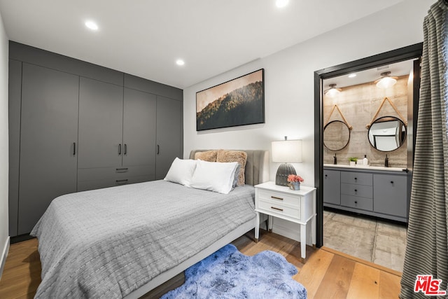 bedroom with light hardwood / wood-style floors and sink