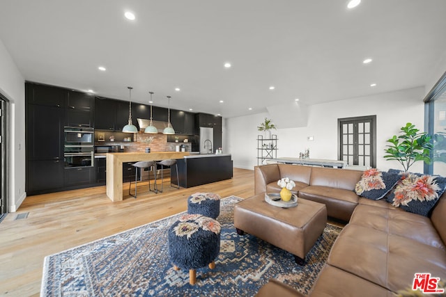 living room featuring light wood-type flooring and sink