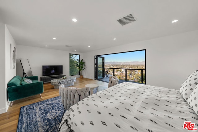 bedroom featuring light wood-type flooring and access to outside