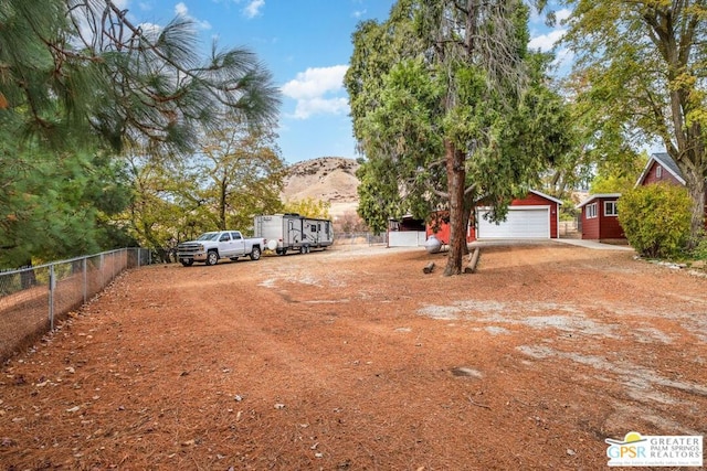 exterior space featuring a garage, a mountain view, and an outdoor structure