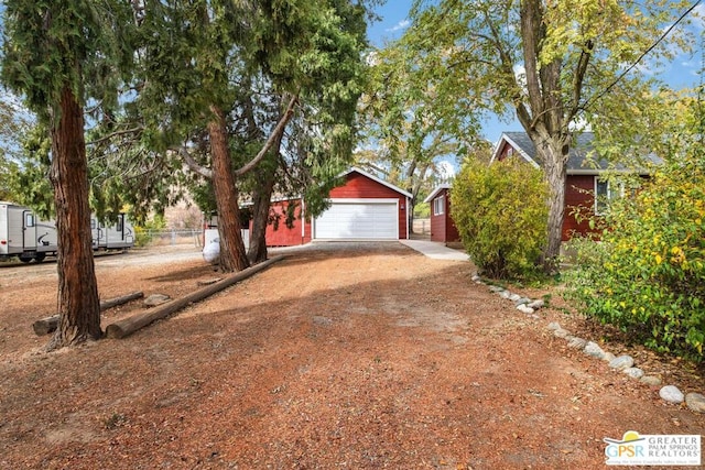 view of front of house featuring a garage and an outbuilding