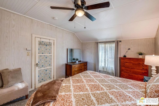 bedroom with ceiling fan, lofted ceiling, and wood walls