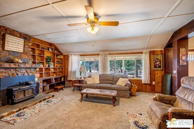 carpeted living room with ceiling fan, a wood stove, a wealth of natural light, and built in features