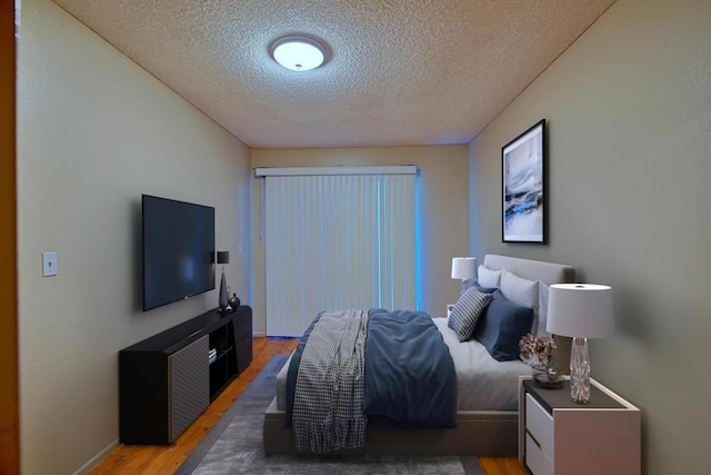 bedroom featuring a textured ceiling and wood-type flooring