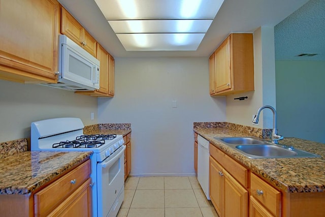 kitchen with light tile patterned flooring, sink, light stone counters, and white appliances