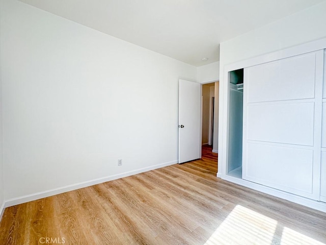 unfurnished bedroom featuring a closet and light hardwood / wood-style floors