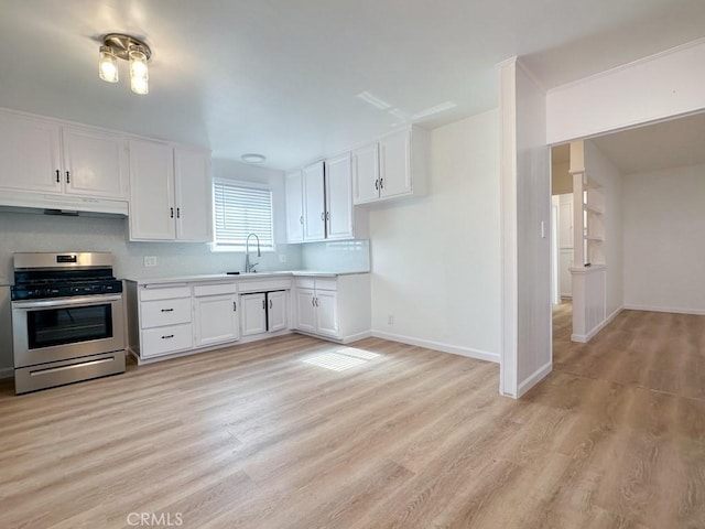 kitchen with white cabinets, light wood-type flooring, sink, and stainless steel stove