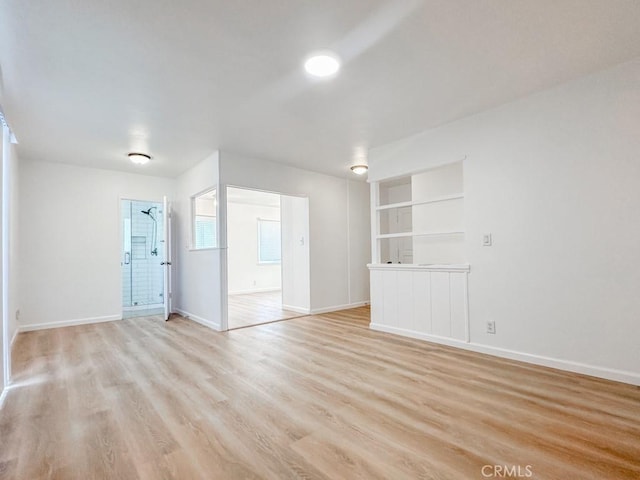 interior space with built in shelves and light hardwood / wood-style floors