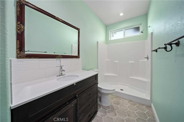 bathroom featuring tile patterned floors, vanity, a shower, decorative backsplash, and toilet