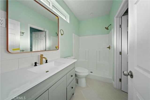 bathroom featuring walk in shower, vanity, toilet, tile patterned flooring, and decorative backsplash