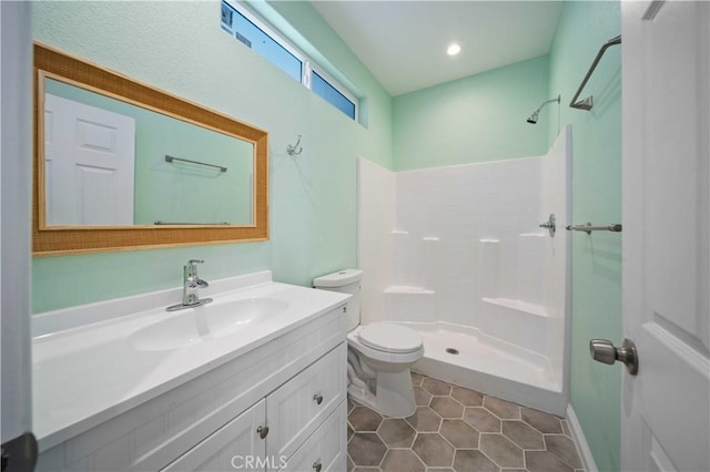 bathroom featuring toilet, vanity, tile patterned flooring, and walk in shower