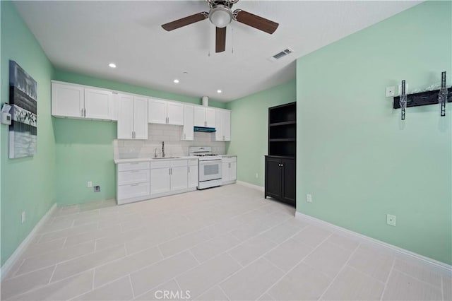 kitchen featuring white cabinets, white range with gas cooktop, sink, backsplash, and ceiling fan