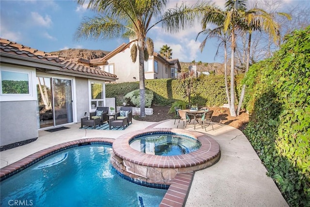 view of pool with outdoor lounge area, a patio, and an in ground hot tub