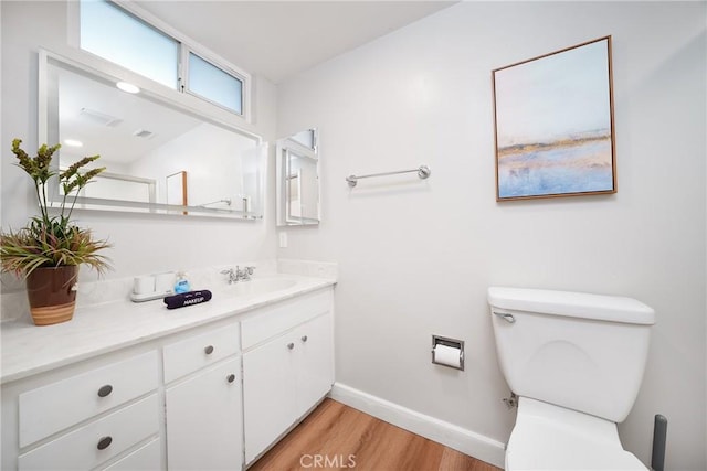 bathroom featuring toilet, vanity, and hardwood / wood-style floors