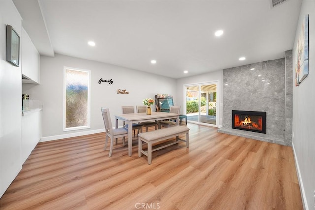 dining space with light hardwood / wood-style flooring and a fireplace