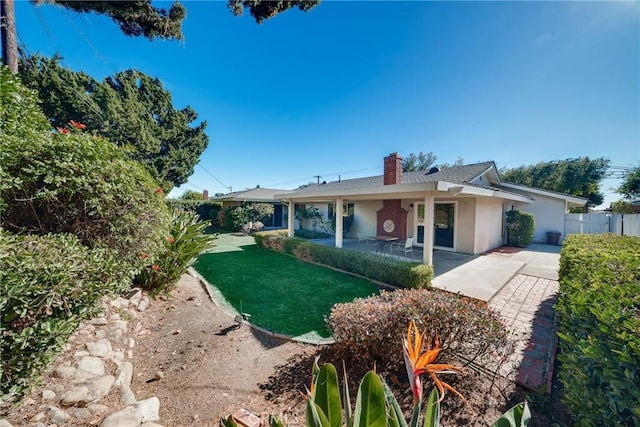 rear view of property featuring a patio area and a yard