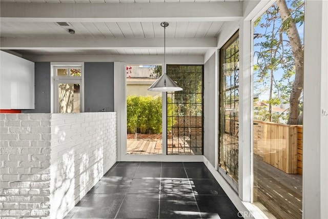 entryway with a healthy amount of sunlight and beamed ceiling