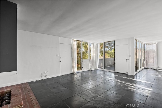 unfurnished room featuring a wall of windows