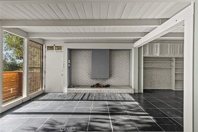 unfurnished sunroom featuring beamed ceiling