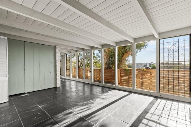 unfurnished sunroom with a healthy amount of sunlight and beamed ceiling