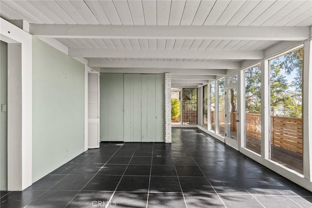 unfurnished sunroom featuring beamed ceiling