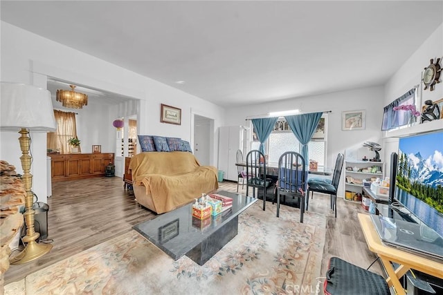 bedroom with light wood-type flooring and an inviting chandelier