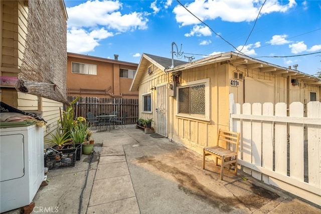 view of property exterior featuring washer / dryer and a patio