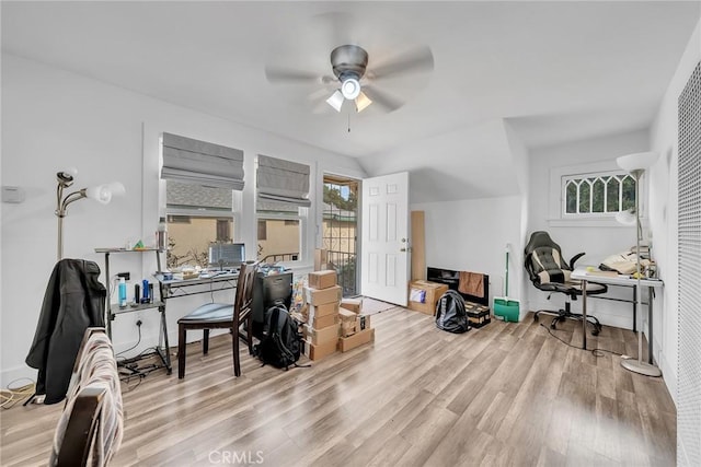 home office with ceiling fan, light hardwood / wood-style flooring, and lofted ceiling