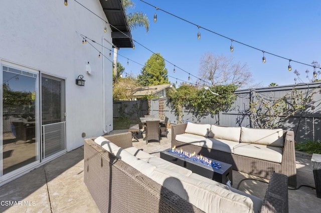 view of patio with an outdoor living space with a fire pit