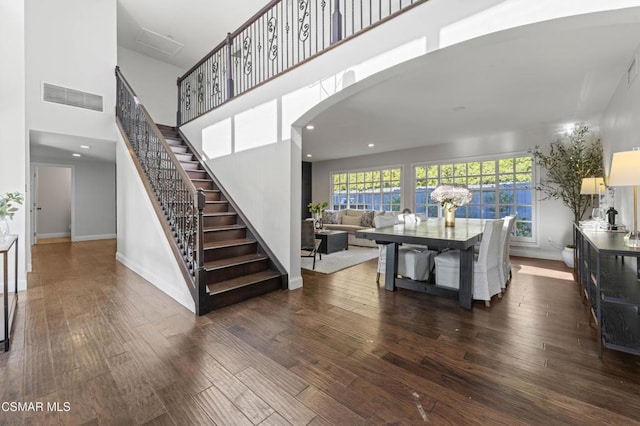 stairs featuring a high ceiling and wood-type flooring