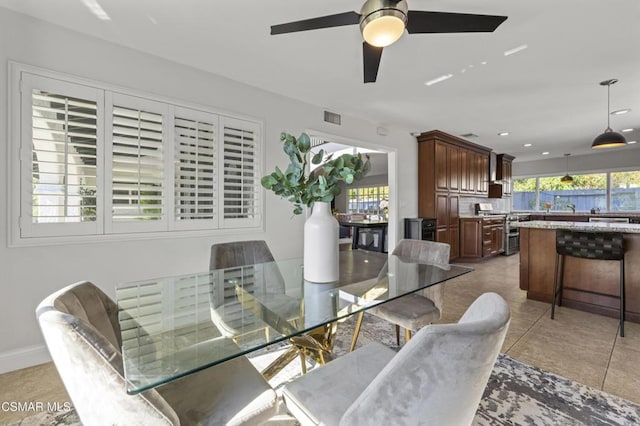 dining space with ceiling fan, sink, and light tile patterned floors