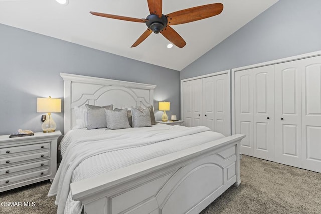 carpeted bedroom with ceiling fan, vaulted ceiling, and two closets