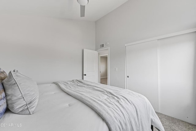 carpeted bedroom with ceiling fan and a closet