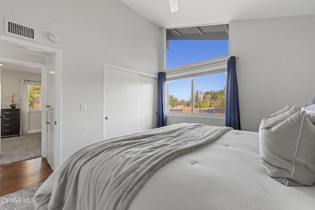 bedroom featuring ceiling fan, a closet, hardwood / wood-style flooring, and lofted ceiling