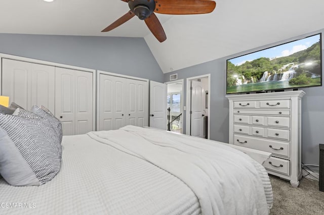 carpeted bedroom featuring ceiling fan, vaulted ceiling, and multiple closets