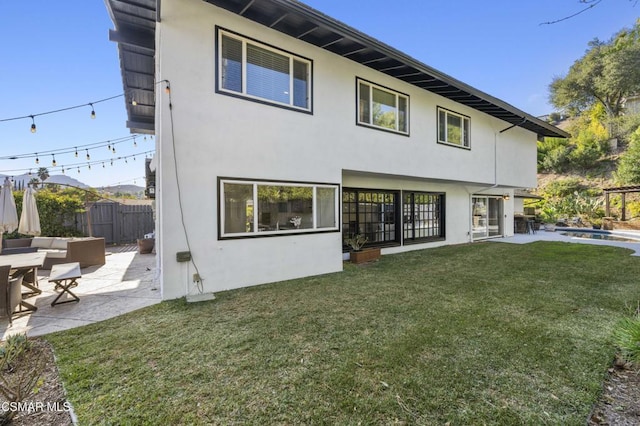 back of house featuring a swimming pool, a patio area, and a yard