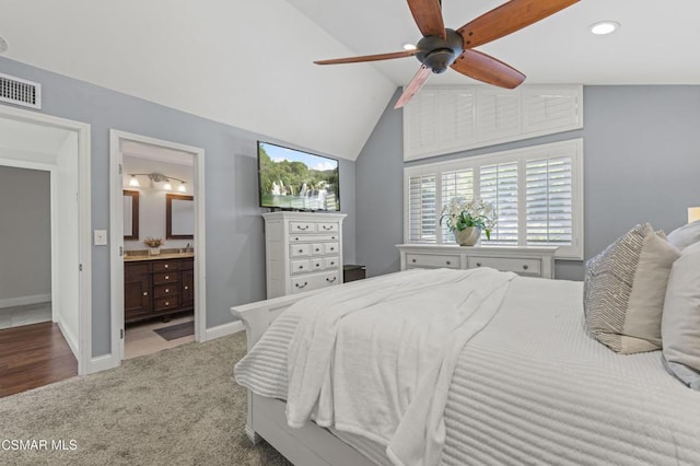 bedroom with ceiling fan, ensuite bath, carpet floors, and lofted ceiling