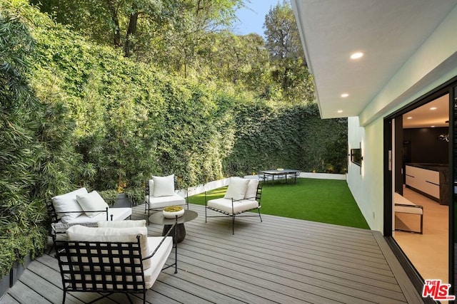 wooden terrace featuring outdoor lounge area and a yard