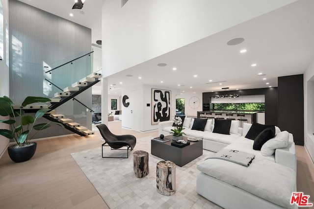 living room with light hardwood / wood-style floors and a high ceiling