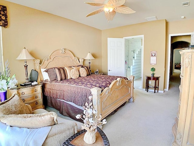 carpeted bedroom featuring ensuite bath and ceiling fan