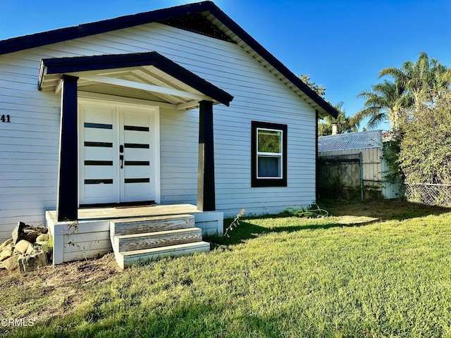 exterior space featuring a front lawn and french doors