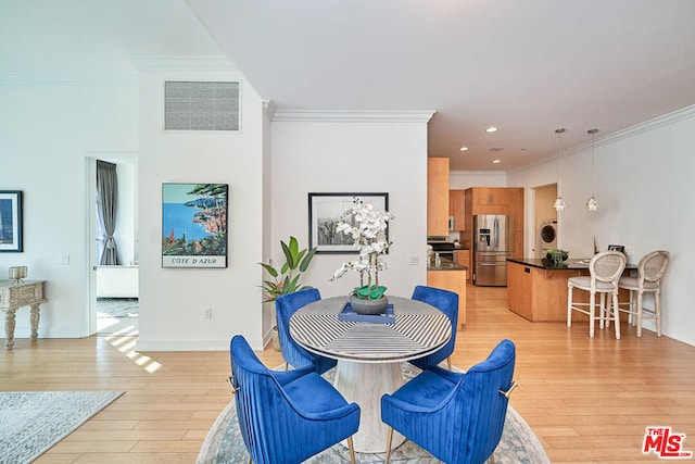 dining room featuring light hardwood / wood-style floors and crown molding